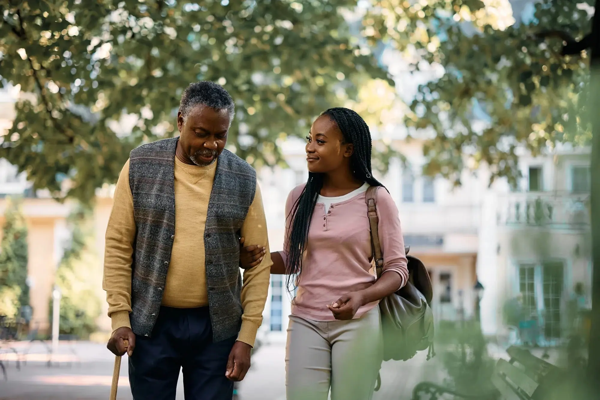 Woman walking with senior father outside Woman walking with senior father outside