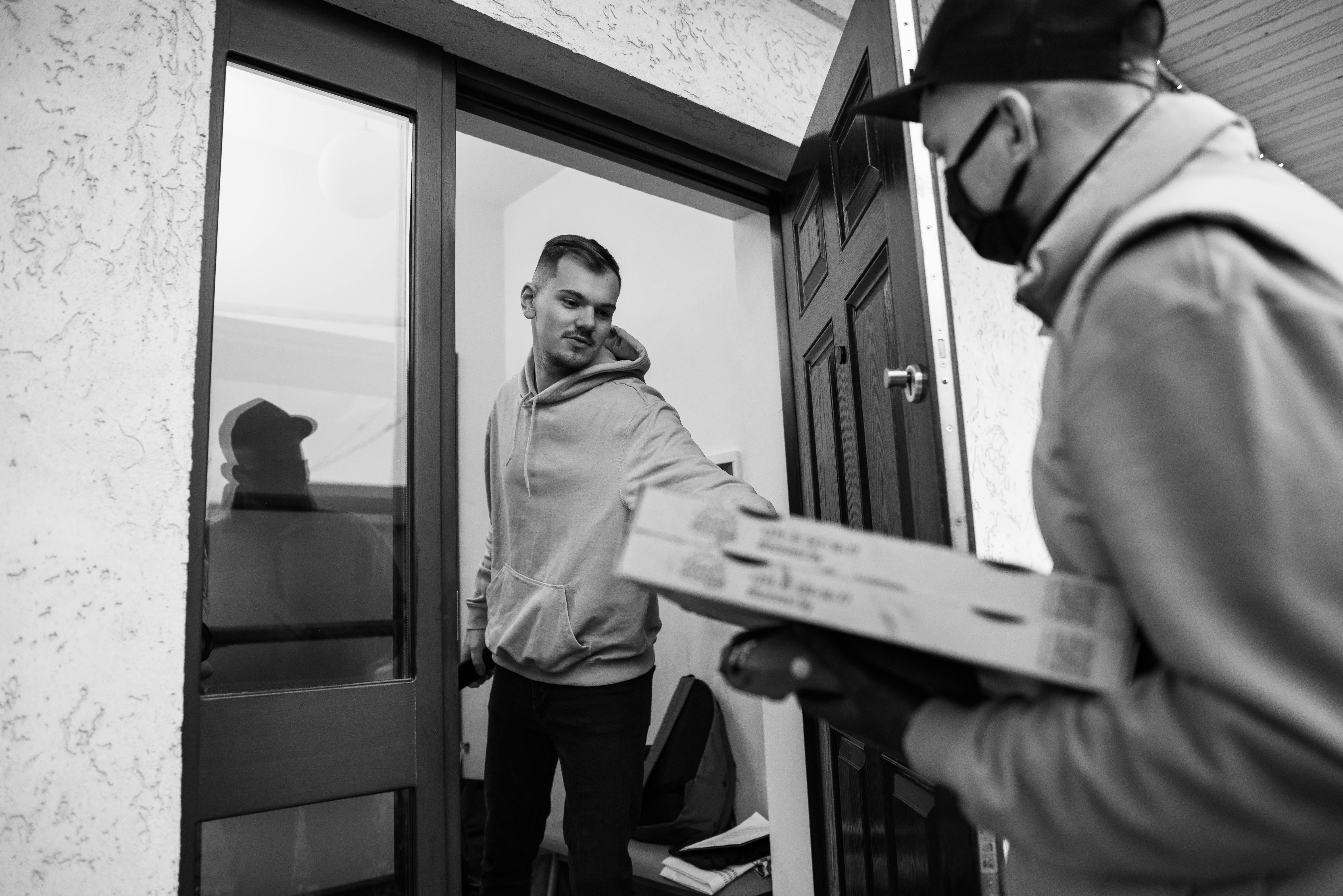 Volunteer delivering a warm meal to a senior at home - community service helping elderly