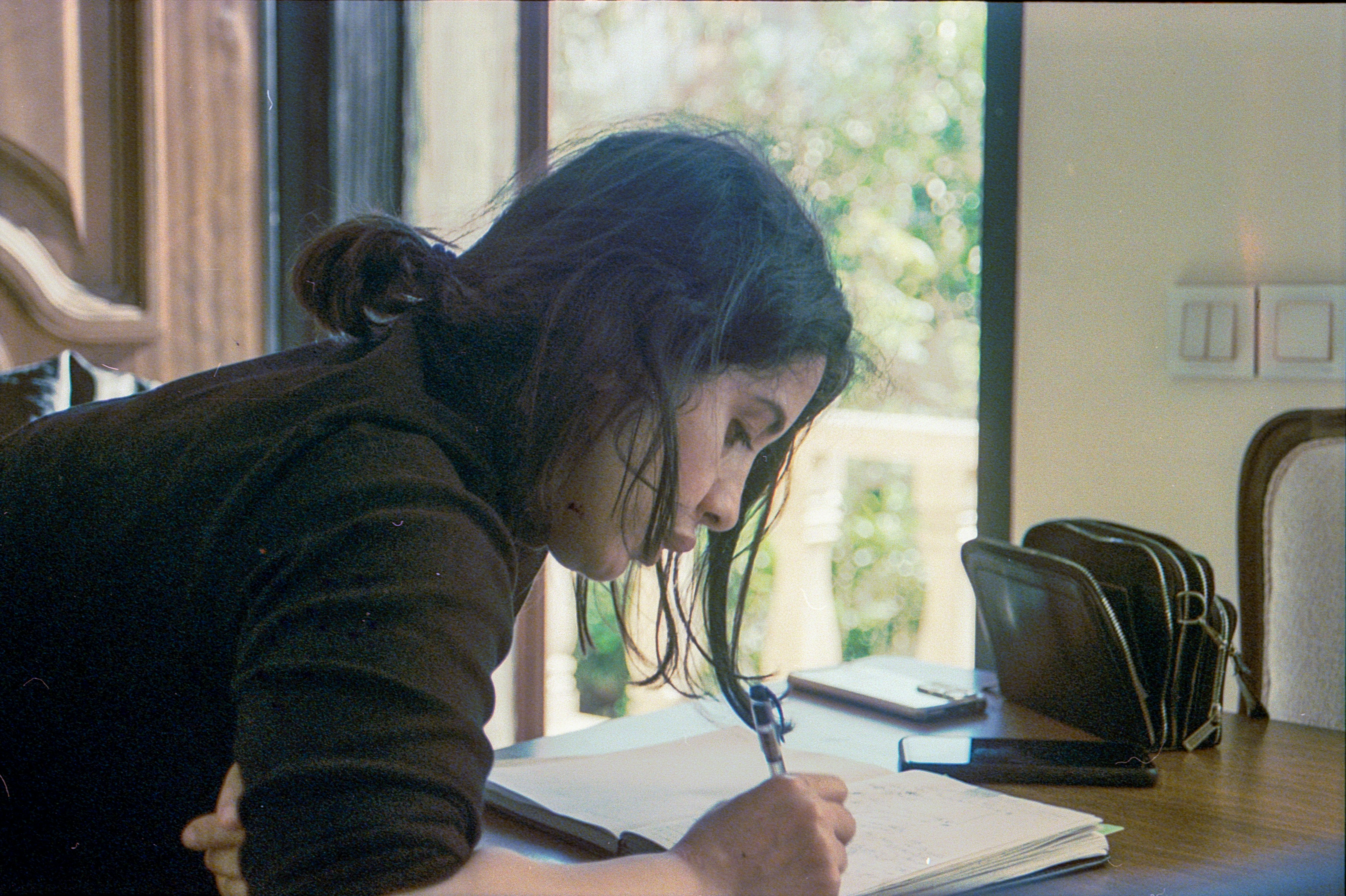 A daughter taking notes during a facility tour to ensure an objective comparison - assisted living checklist