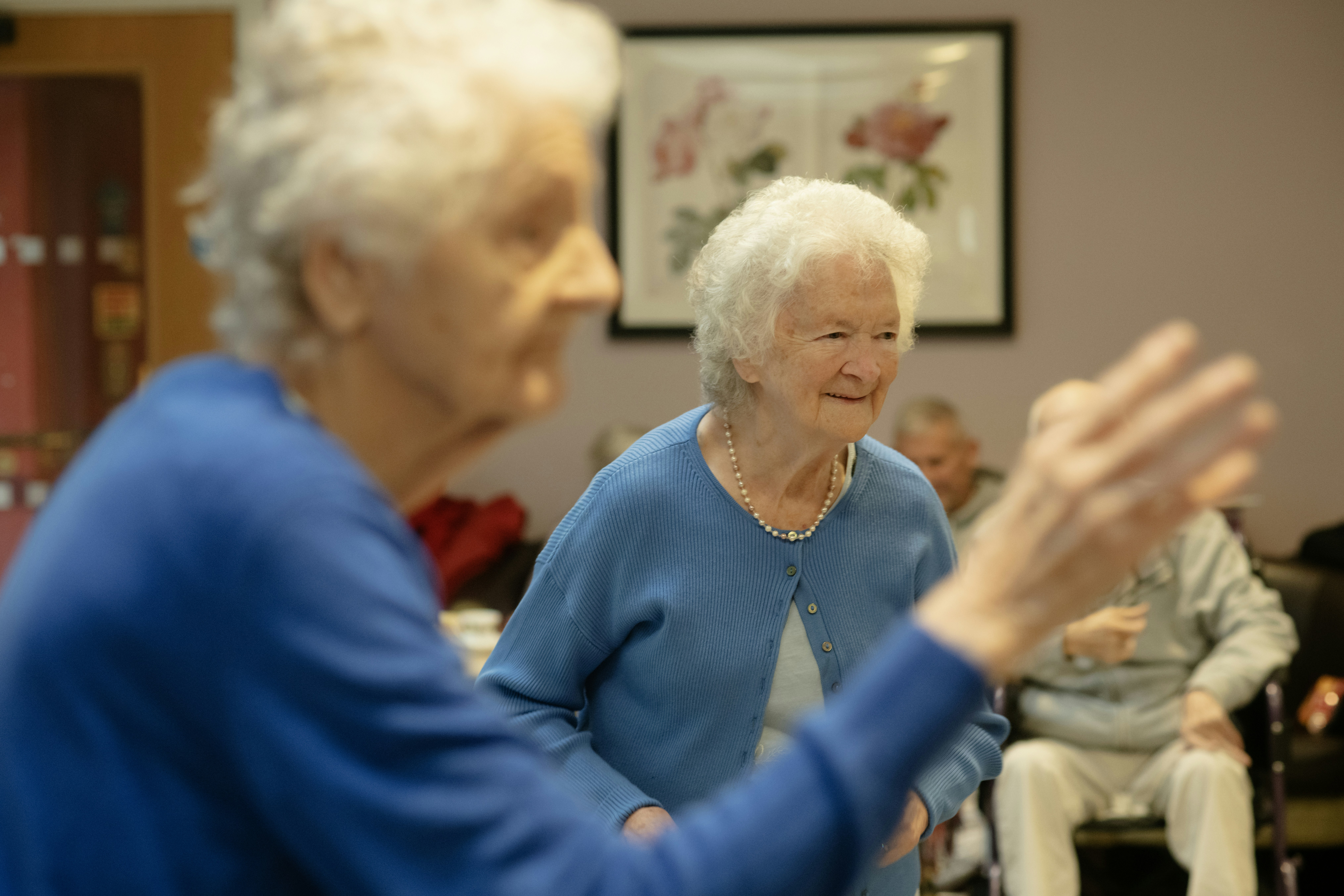 Senior woman smiling while participating in a group water aerobics class with friends - social engagement elderly