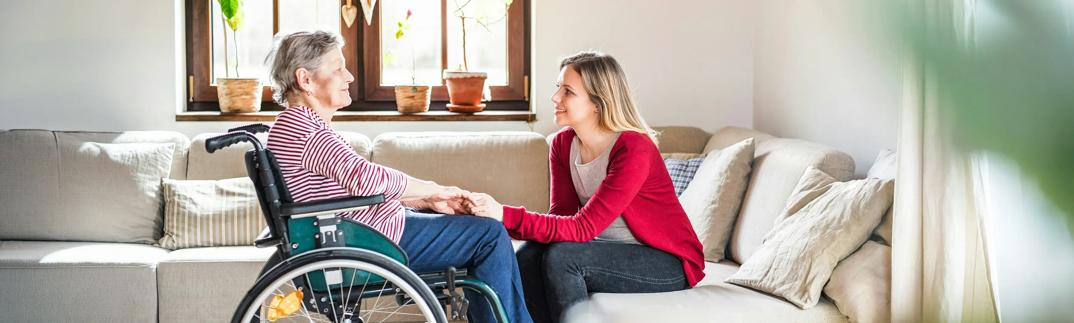 Elderly woman and caregiver holding hands