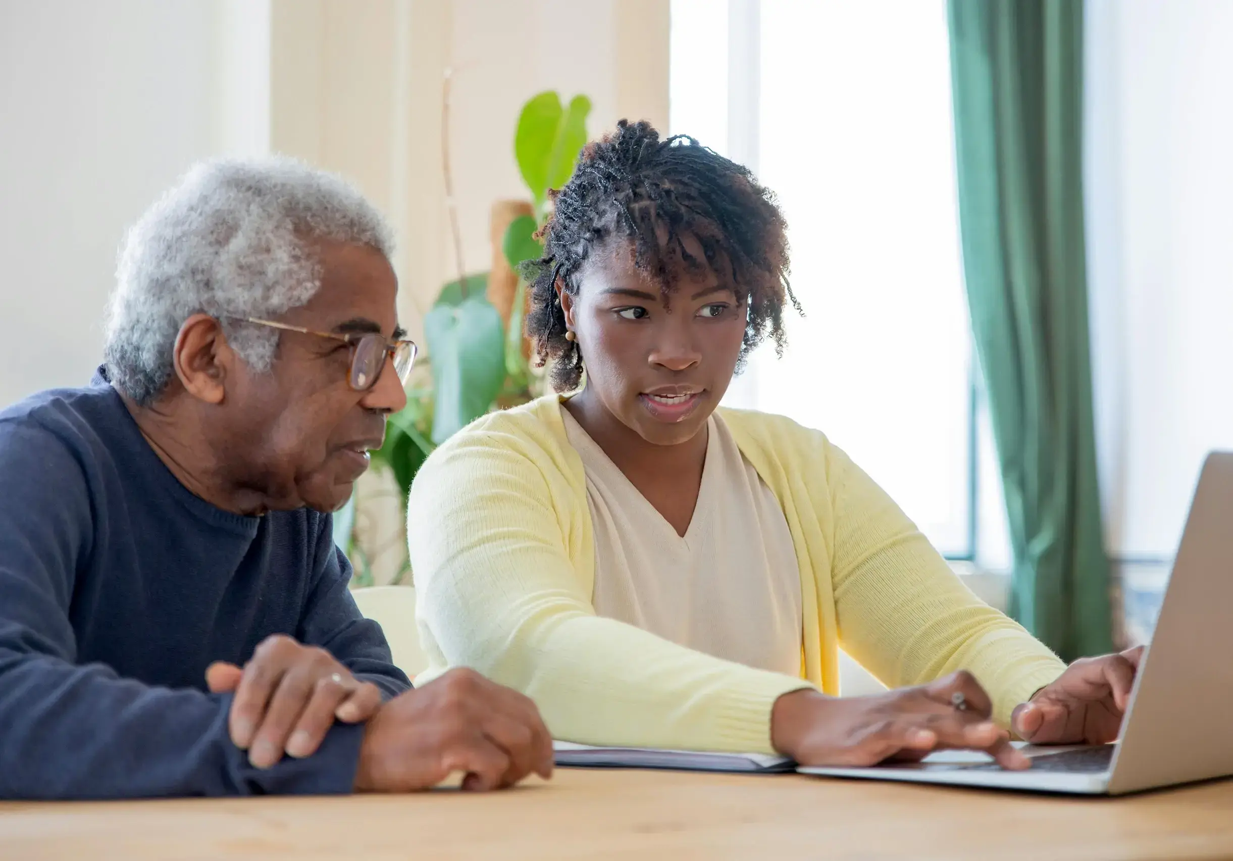 Elder and caregiver at laptop
